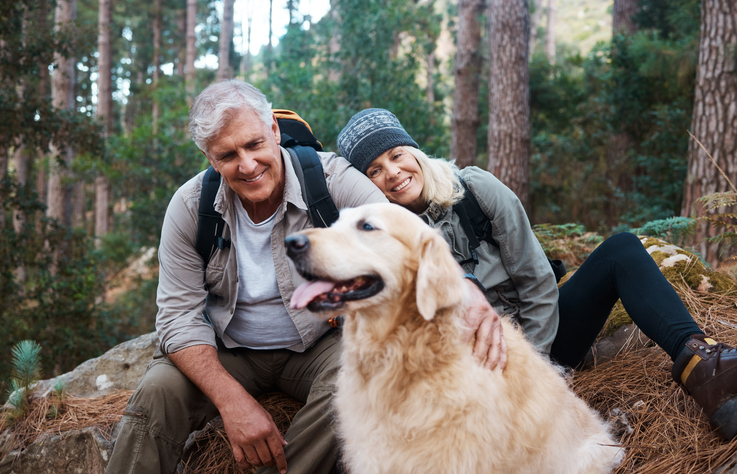 Ouder koppel met hond in het bos