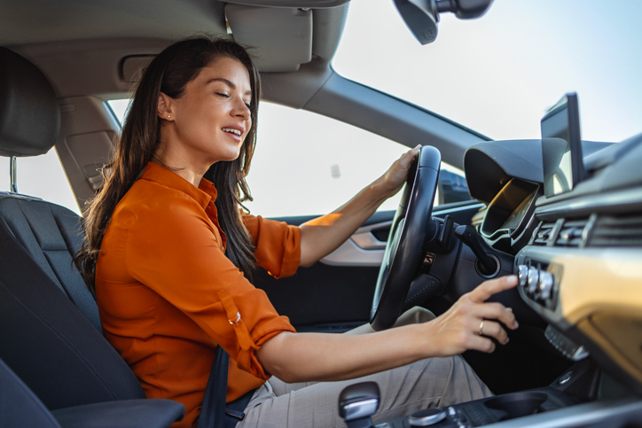 Vrouw zet airco aan in auto