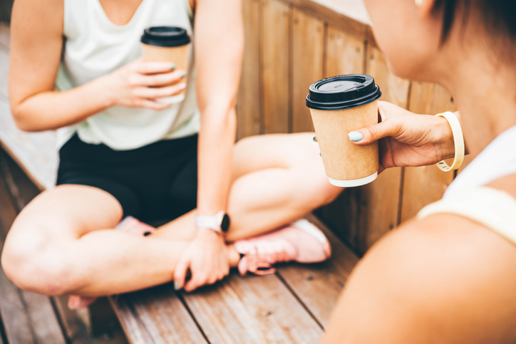 Twee personen drinken koffie op een bank