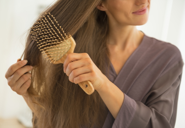 Vrouw borstelt lang bruin haar
