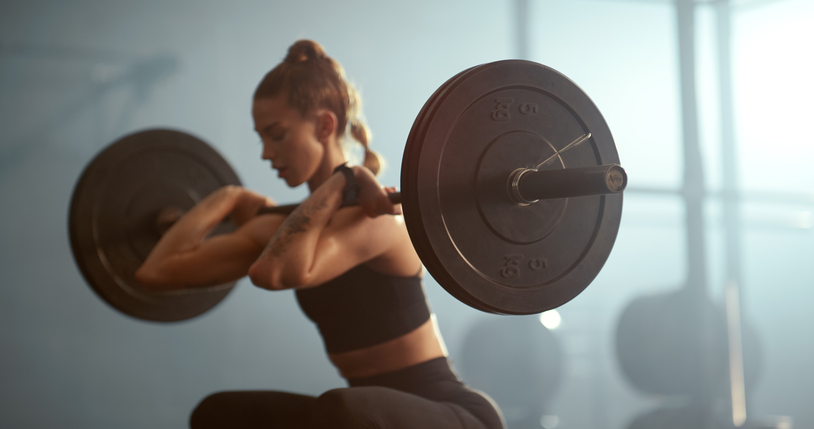 Vrouw doet front squat in de sportschool