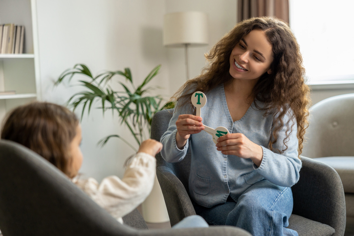 Vrouw leert kind om letters goed uit te spreken
