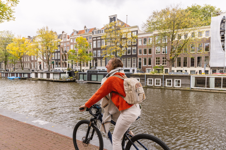 Vrouw fietst door de stad (amsterdam)
