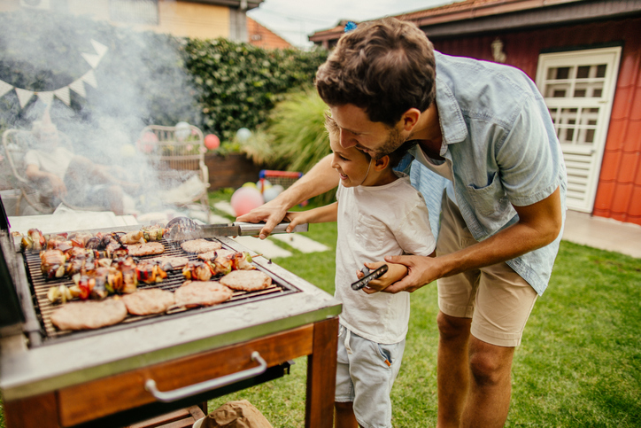 Man en kind zijn aan het bbqen